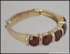 A 9ct gold hallmarked ladies dress ring being channel set with 5 ruby garnet stones.