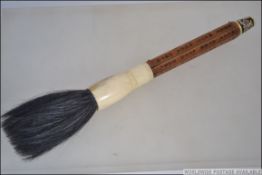An unusual Chinese - asiatic calligraphy brush having a wooden handle incised with character marks,