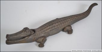 A vintage early 20th century pair of cast metal nut crackers in the form of a crocodile.