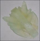 A Chinese celadon jade belt buckle carved into the form of a dragon L6cm