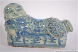 A Chinese blue and white ceramic pillow in the form of a recumbant buddha ( see illustrations ).