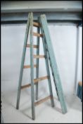 A pair of vintage mid century vintage wooden builders trestle stands with metal clasp to the top,