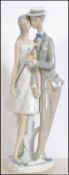 A Lladro 20th century Spanish ceramic figure group diorama of a young couple having impressed