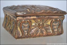 A 19th century gilt on copper Art Nouveau snuff tin with a naturalistic scene in relief to the lid,