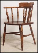 A Victorian beech and elm smokers bow Windsor armchair being raised on turned legs united by