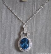 A modern silver cz and blue topaz adorned necklace and silver chain stamped 925.
