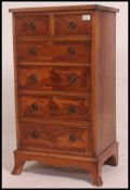 A Regency Revival yew wood veneer bachelors chest of drawers being raised on french kick legs with