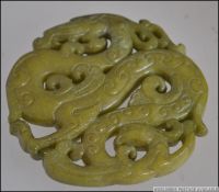 A Chinese carved Jadeite Bi depicting dr