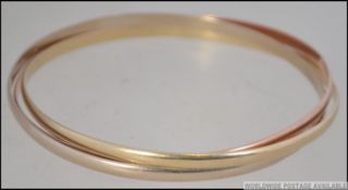 A 9ct gold 3 coloured puzzle bangle. Sta