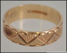 A 9ct gold band ring with concentric hea