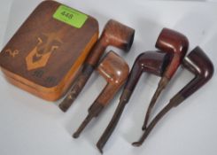 A collection of vintage pipes along with a tobacco tin,