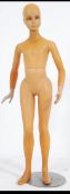 A vintage 20th century shop window mannequin / dummy of a child raised on a chrome circular base.