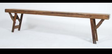 A vintage early to mid 20th century pine folding school hall - village bench with a slatted three