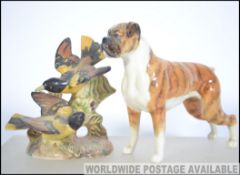 A Beswick figure of a boxer dog along with a Beswick group figure of a pair of Baltimore Oriels