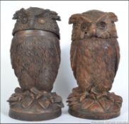 A pair of 20th century Black forest carved owl tobacco jars and covers in the form of seated owls.