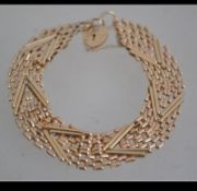 A hallmarked 9ct gold fancy link bracelet with heart lock. Hallmarked Birmingham. Weight 15g.