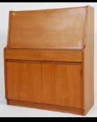 A retro 20th century teak wood fall front bureau with fully appointed interior over two drawers and