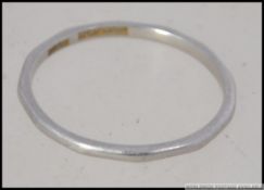 A platinum band ring of ribbed design. The inside shank stamped platinum, makers WW Ltd. Size Q.