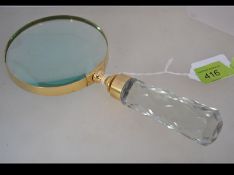A contemporary large hand held magnifying glass with decorative faux glass handle and circular