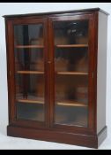 An Edwardian style mahogany library bookcase cabinet being raised on plinth base with twin glazed