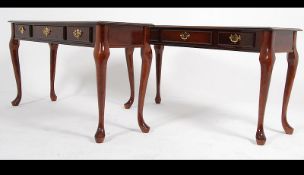 A pair of antique style mahogany console - hall tables raised on shaped legs with twin drawers and
