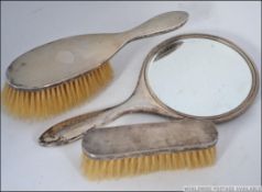 A group of three silver hallmarked dressing table brush set, having engine turned geometric design.