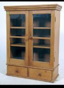 A 19th century pine cabinet cupboard having 2 short drawers under glazed cabinet above with shelf