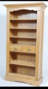 A contemporary tall open Oak bookcase having three adjustable shelves above two drawers with a