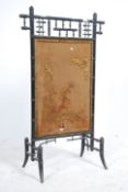 A Victorian Aesthetic movement fire / discretion screen in ebonised bamboo with a central silk