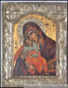 An orthodox Russian Icon depicting The Virgin Mother and Child within a stylistic silver plate