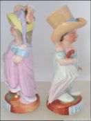 A pair of continental 19th century German porcelain figurines of children in dressing up clothing.