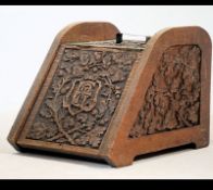 A 19th century Victorian carved oak coal purdonium with carved fret worked front and handle atop.