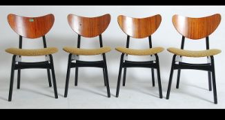 A set of 4 1970's G-Plan teak wood butterfly chairs being raised on ebonised tapered supports with