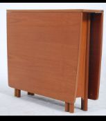 A 1970's teak wood drop leaf dining table raised on bow end legs with turned feet having gate leg