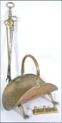 A 19th century brass log basket raised on hairy paw feet together with fire irons and brass hanging