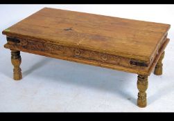 A late 20th century rustic pine coffee table raised on turned legs with metal bracket work