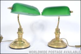A pair of vintage style 20th century bankers desk lamps having green glass shades raised on brass