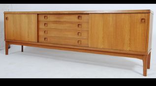 A 1970's good Danish blond teak wood sideboard raised on squared legs with a series of cupboards