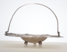 An Indian silver peanut dish with scrolled handle.