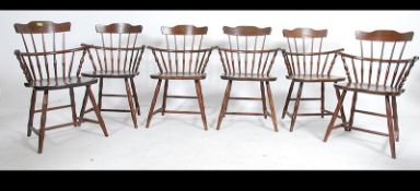 A set of six 20th century Goldsmith style windsor dining chairs raised on spayed legs united by