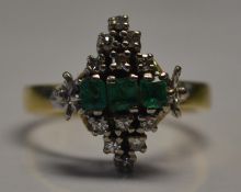 A 18ct gold Art Deco diamond and emerald ring set with three central cushion cut emeralds with