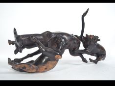 An unusual African carved tribal figurine of a lion and lioness attacking a water buffalo dating to