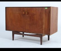 A 1970's vintage Danish inspired teak wood sideboard of small proportions raised on tapered legs