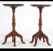 A pair of 20th century wine tables, having a circular top raised on column support on quad feet.