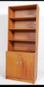 A 1970's G-Plan teak wood upright bookcase room divider having bank of drawers to the base with