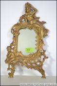 A rococo gilt wall mirror of cast metal form having applied putti and vine decoration with central