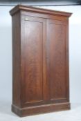 A Victorian English pine double wardrobe being raised on a plinth base with twin full length double