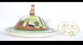 A fabulous Dartmoor ware cheese dish with handpainted countryside scene adorned with a mouse finial.