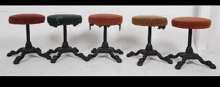 A collection of five vintage early 20th century cast metal pub stools,
