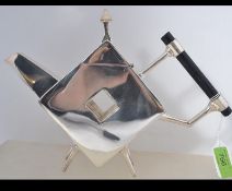 A silver plated teapot in the manner of Christopher Dresser being raised on legs with top above